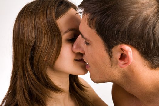 Young adult couple in the studio kissing