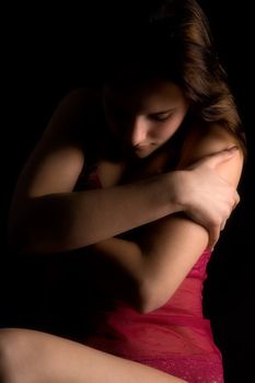 Studio portrait of a woman in luxurious lingerie in a low key setting