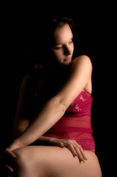 Studio portrait of a woman in luxurious lingerie in a low key setting