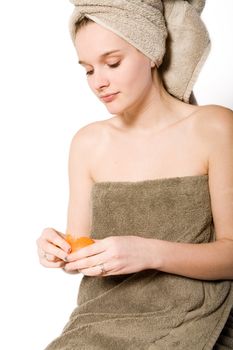 Young woman on a white background  in towel caring for herself