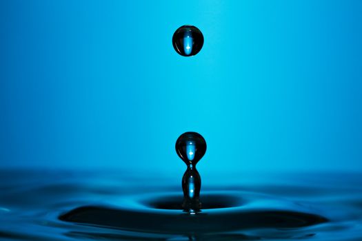 Macro photo of a perfect water drop on blue background.