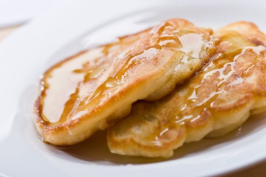 Two pancakes with honey on plate, lunch