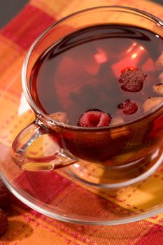 Cup of tea with raspberry syrup and some raspberries