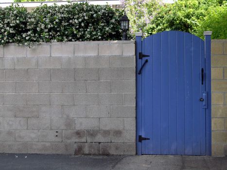 a blue gate set into a grey brick wall.