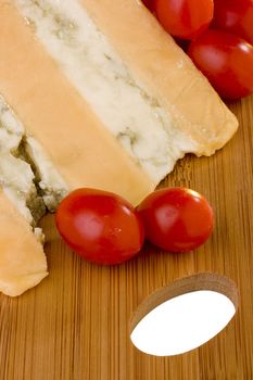 Gloucester cheese with Cheese blue slice on a wood desk with tomato.