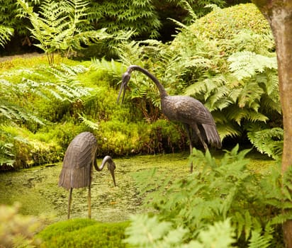 Carved storks in Japanese garden pond
