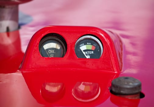 Antique warning dials on red painted tractor