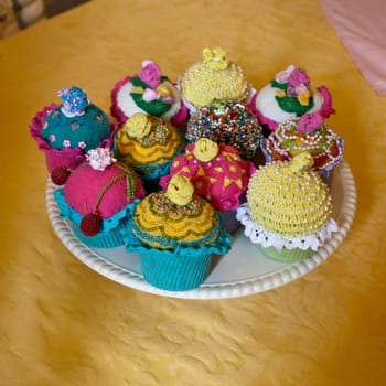 Unusual knitted or crocheted cakes and buns on a white plate