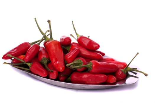 Detail view of a bunch of red chili peppers scattered isolated on a white background.