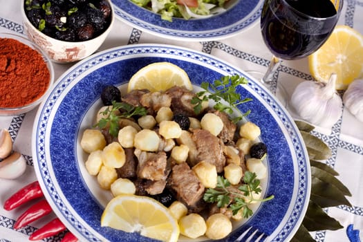 Close up view of a Portuguese meal of cooked meat with potatoes.