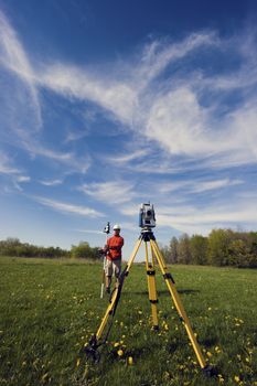 Land Surveyor working with robotic station - spring time.