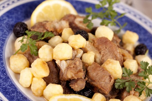 Close up view of a Portuguese meal of cooked meat with potatoes.