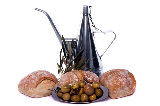 Detail view of some olives on a plate, some bread and a recipient for olive oil.