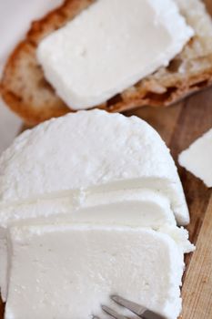 Portuguese, fresh and traditional cheese and bread sliced on a table.