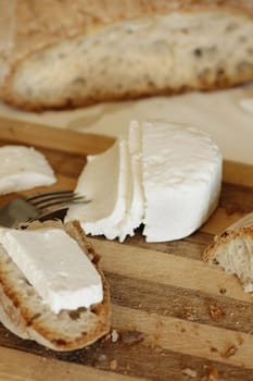 Portuguese, fresh and traditional cheese and bread sliced on a table.