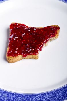 Close view of a toasted bread with berry jam spread  isolated on a white background.