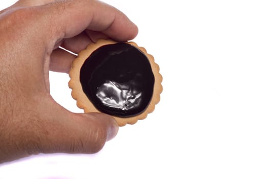 View of a round biscuit isolated on a white background covered with dark chocolate.