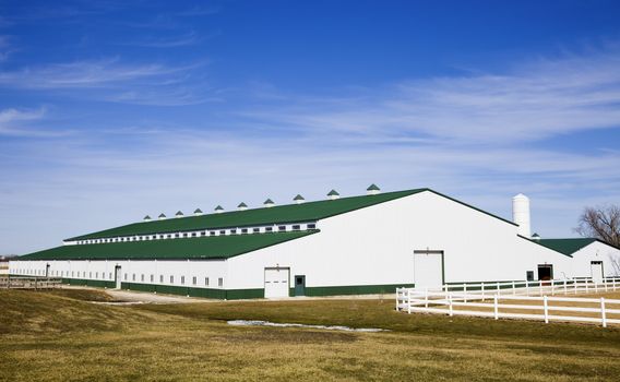 White stable with green roof seen late winter.