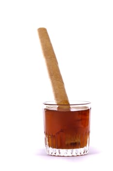 Close up view of a glass of honey with cookie roll isolated on a white background.