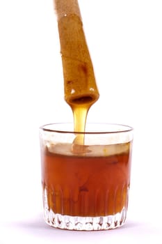 Close up view of a glass of honey and another of chocolate with cookie rolls.