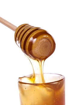 Close up view of honey dipper with honey dripping isolated on a white background.