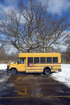 Small school bus on the parking lot - winter time.