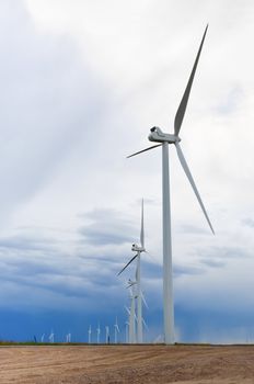 Row of wind turbines lined up on the horizon after a rain storm