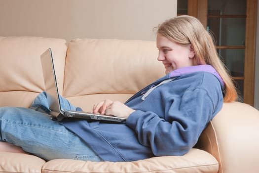 teenager using laptop or notebook on sofa