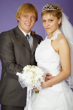Wedding portrait of the newlyweds on a purple background