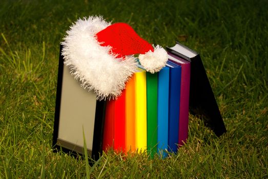 Electronic book reader wearing Santa's hat with row of books