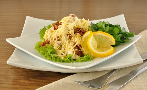 Salad with cheese and apple, walnuts and yogurt on lettuce leaves with lemon