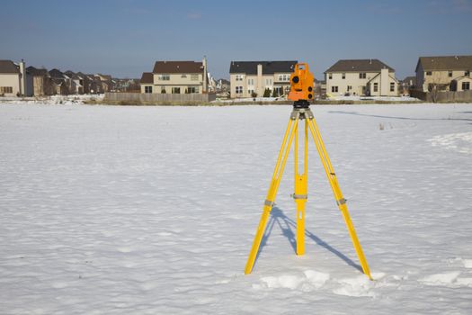 Orange theodolite set in the field - winter time.