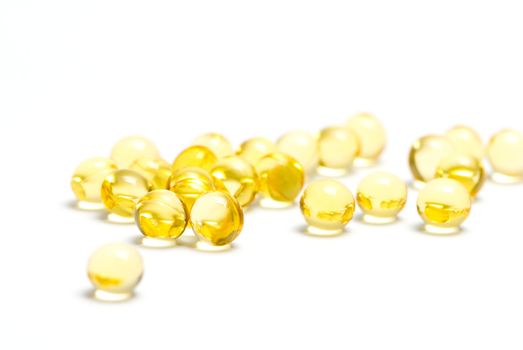 Yellow capsules of fatty acids isolated on white