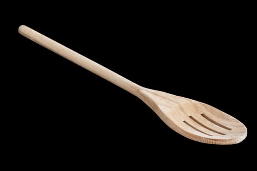 A slotted wooden kitchen spoon isolated on a black background.