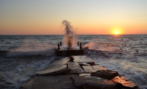 Wave splashes over beautiful sunset