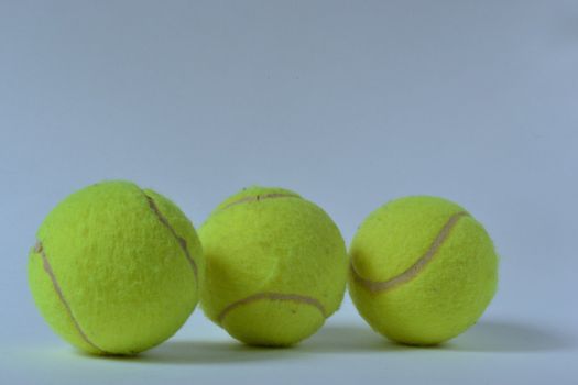 Three tennis balls over white background