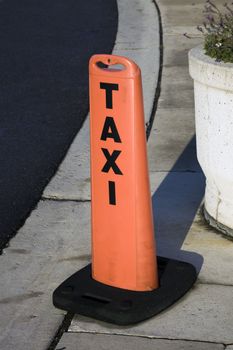 Taxi sign next to the road.