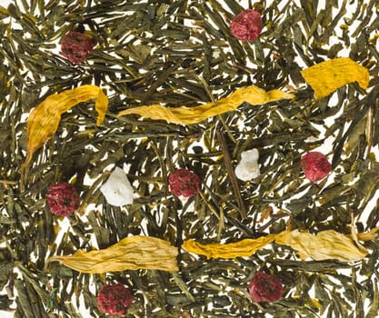 Background image consisting of tea leaves and dry fruits with focus on berries