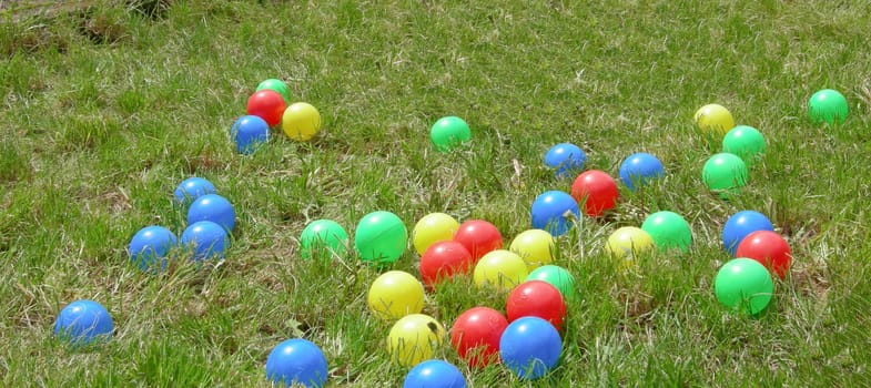 Coloured plastic balls in the grass