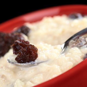 Rice pudding with raisins on spoon (Selective Focus, Focus on the front of the raisin on the spoon)
