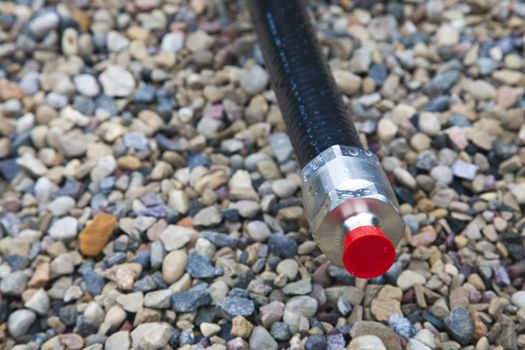 Coax cable with connector on gravel background.