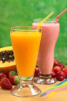 Papaya juice and strawberry milkshake with straws (Selective Focus, Focus on the straw in the papaya juice)