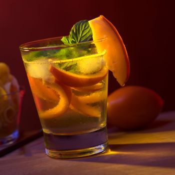 Tamarillo cocktail (Selective Focus, Focus on the tamarillo slice on the rim of the glass)