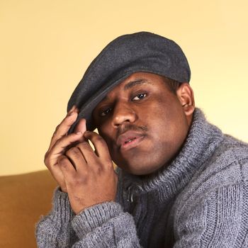 Portrait of a serious young man of African descent with a cap (Selective Focus, Focus on the left eye)