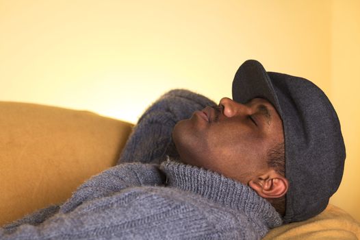 Portrait of a young man of African descent taking a nap on a sofa (Selective Focus, Focus on the left eye)