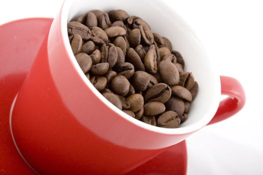 Close up of red cup filled with coffee beans. 