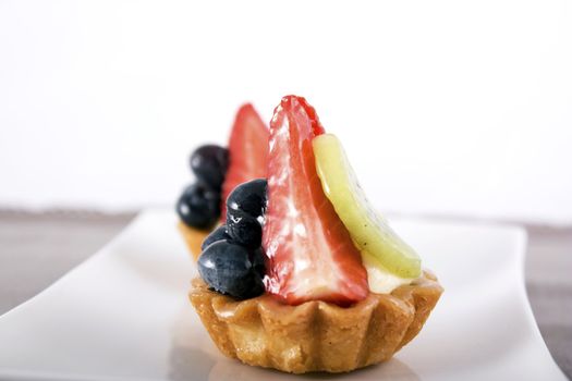 Mini pie pastries with fresh strawberry, blueberry and kiwi fruit.