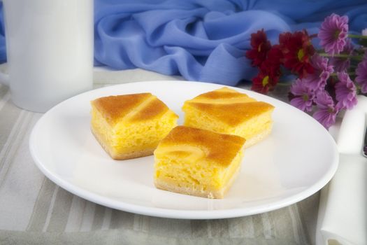 Three pieced of yellow cake on white plate.