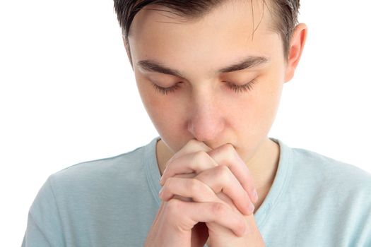 A boy sits quietly in contemplation, deep thought, meditation or silent prayer