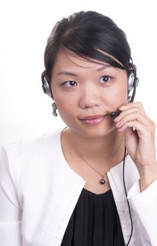 Young asian receptionist talking on hands free headset to customer isolated